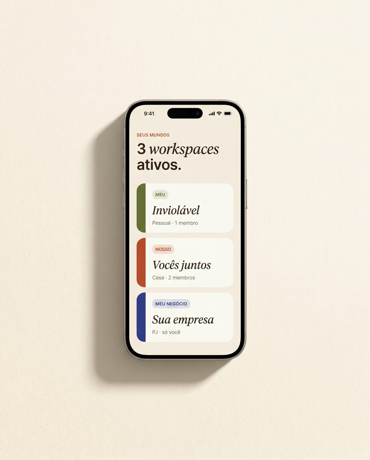 Tela do app Nós Finanças mostrando os 3 workspaces: Meu (olive), Nosso (terracotta) e Meu Negócio (indigo) — cada um com chip, título em serif italic e contagem de membros.